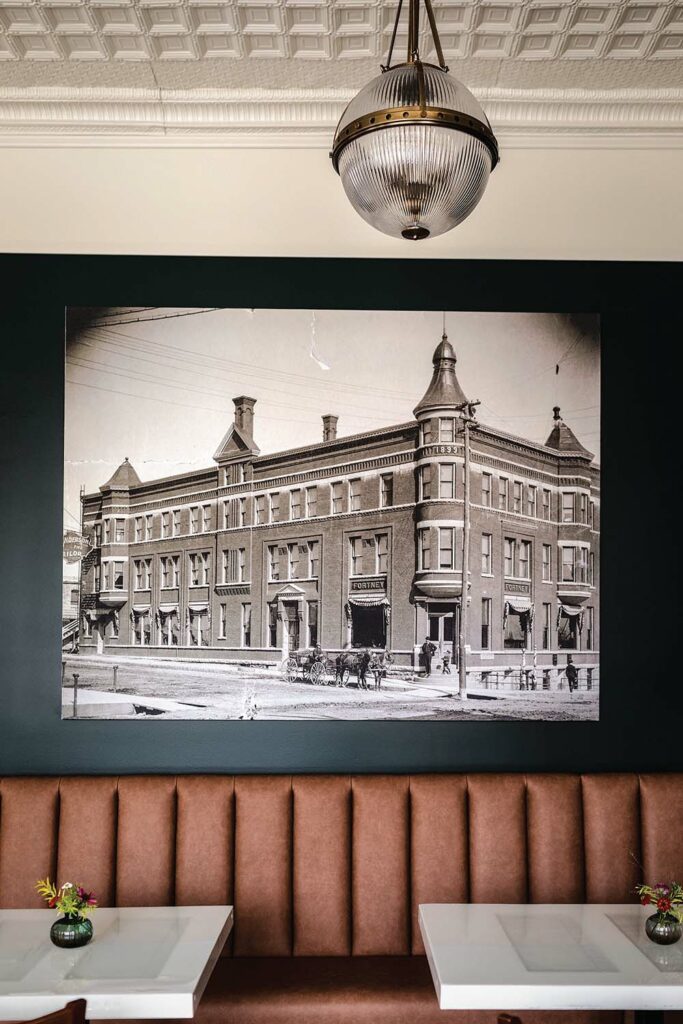 The Historic Fortney Lounge displays a large photo of The Hotel Fortney building as it once looked above some tables and booth seating